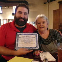 A certificate of appreciation is presented to Mazzy's Sports Bar and Grill
