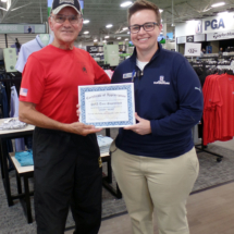 A certificate of appreciation is presented to PGA Tour Superstore