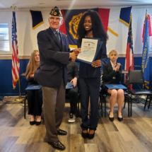 Commander Chuck Guta presents Lindsey McNeal with her First place certificate and check.